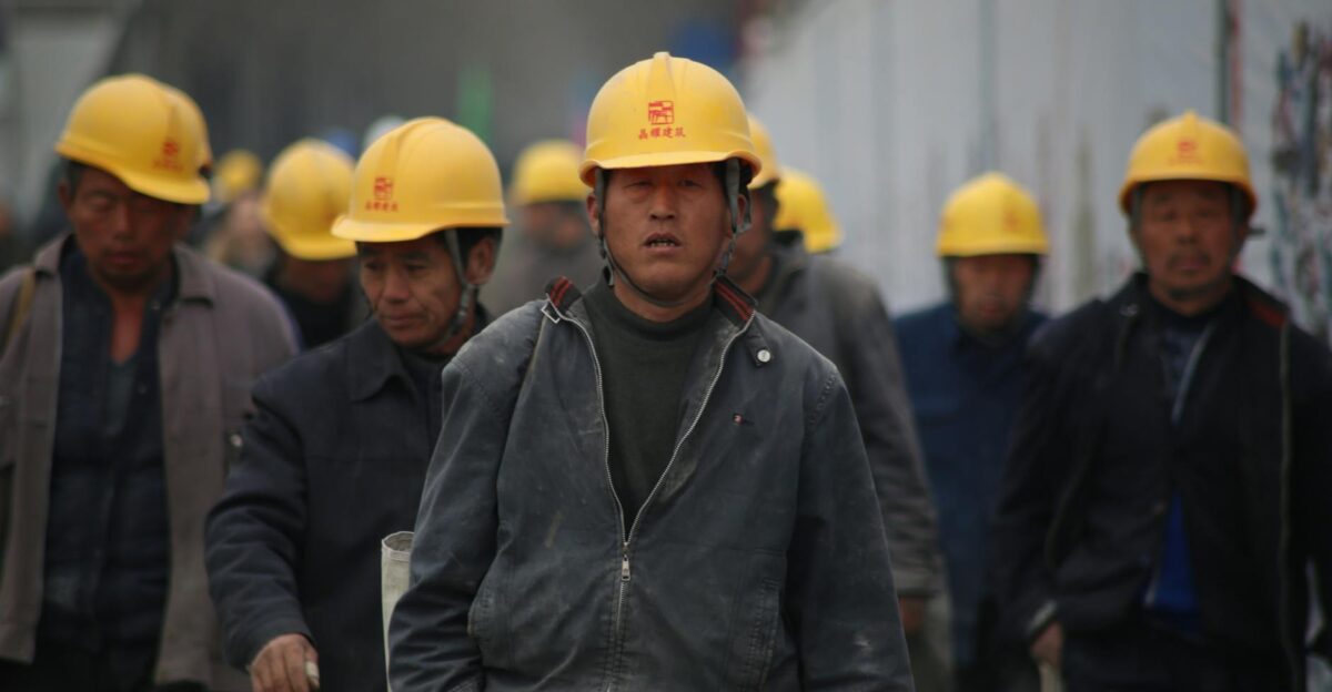 Construction workers in hard hats walking at a site highlighting teamwork and safety
