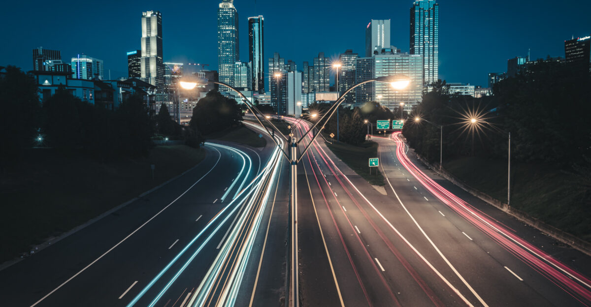 An image of the Atlanta Georgia Skyline taken at dawn with long exposure to create light trails of the morning traffic Taken from the Jackson Street Bridge that passes over the John Lewis Freedom Parkway