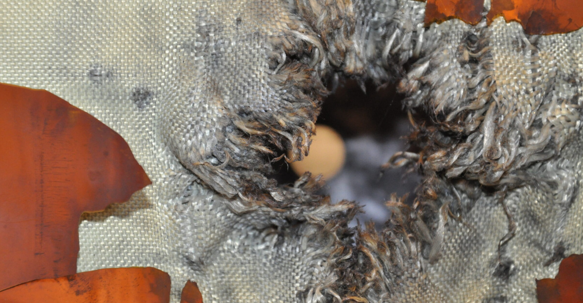 An exit hole through Kevlar–Nextel fabric after hypervelocity testing of the multilayer shielding for ESA’s ATV space freighter, simulating an impact by space debris. The good news is that testing confirms the spacecraft's pressure shell would survive such a collision intact.
<p>Testing was carried out for ESA’s Space Environment and Effects section at the Fraunhofer Institute for High-Speed Dynamics, Ernst-Mach-Institut, EMI, in Freiburg, Germany, using a high-performance light-gas gun.
A 7.5 mm-diameter aluminium bullet was shot at 7 km/s towards the same ‘stuffed Whipple shield’ design used to protect the ATV and the other International Space Station manned modules.
This represents the upper end of the size of debris the shield is designed to cope with. Multiple layers give greater protection than a single thick aluminium layer.
The debris begins by piercing ablanket of multilayer insulation, followed by a 1 mm-thick aluminium ‘bumper shield’.
This impact makes the solid object break apart into a cloud of fragments and vapour, which becomes easier for the following layers to capture or deflect. Next comes the layer of stuffing seen in this main photo, a weave of lightweight Kevlar and Nextel fabric, which further slows the incoming debris.
The stuffing fabric and a surrounding sheet has been thoroughly shredded by the impact, but the overall mass and energy of the debris has been sufficiently dissipated that it has merely harmlessly scorched the innermost 3-mm-thick aluminium wall.
In orbit, this entire shield measures just 128 mm across.
The stronger-than-steel Kevlar fabric was invented by Stephanie Kwolek of the DuPont company, who died this month.
On Earth, her invention’s ‘killer app’ proved to be bulletproof vests; its use on the Space Station helps to ensure that module hulls could be designed several centimetres thinner than would otherwise be the case.
</p>
ESA’s next and finalATV,Georges Lemaître, will be launched to the orbital outpost this summer.