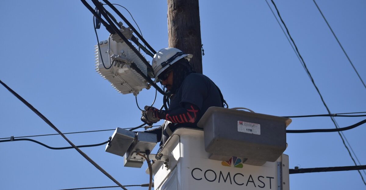 cable repairman technician comcast xfinity repairman maintenance electrician electrical wires wiring repair professional utility pole service electrical cables electricity hard work worker hardhat job houston texas dangerous work environment employment 2024-2025