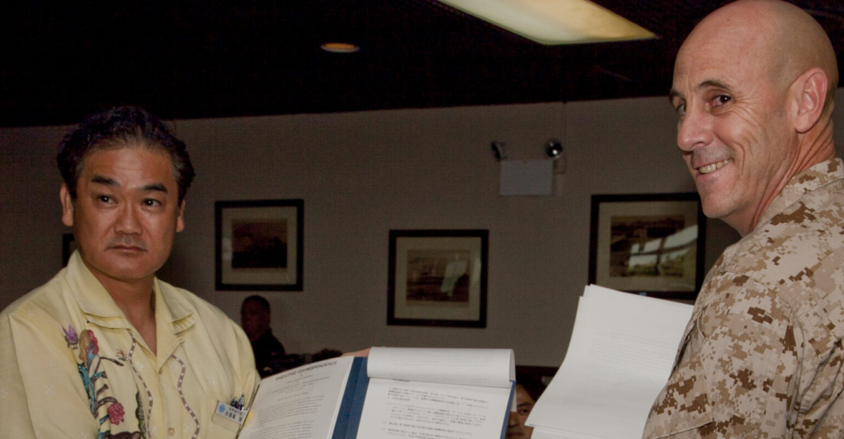 Mayor Atsushi Sakima, and Col. James G. Flynn display their signed copies of a bilateral agreement June 26 on Marine Corps Air Station Futenma. The agreement specifies evacuation methods for Okinawa residents to transit through the air station in the event of a natural disaster and provides for evacuation drills to maintain preparedness. Sakima is the mayor of Ginowan City, and Flynn is the commanding officer of MCAS Futenma. (U.S. Marine Corps photo by Lance Cpl. Elizabeth A. Case/Released)