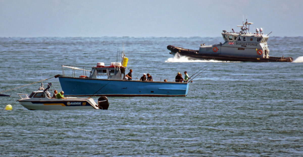 Sea fishing boats and HMCPV Eagle a Border Force 20 metre-long rigid-hulled inflatable craft with a crew of six and speed in excess of 30 knots 35mph one of four from 2016 tasked largely with intercepting illegal immigrant traffickers attempting landings in Kent and Sussex from France following the demolition of the Calais Jungle patrolling eastbound one mile off the coast with photo taken from Victoria Parade on Viking Bay at Broadstairs in Kent England Camera Canon PowerShot SX60 HSSoftware File lens-corrected optimized perhaps cropped with DxO OpticsPro 11 Elite and likely further optimized with Adobe Photoshop CS2