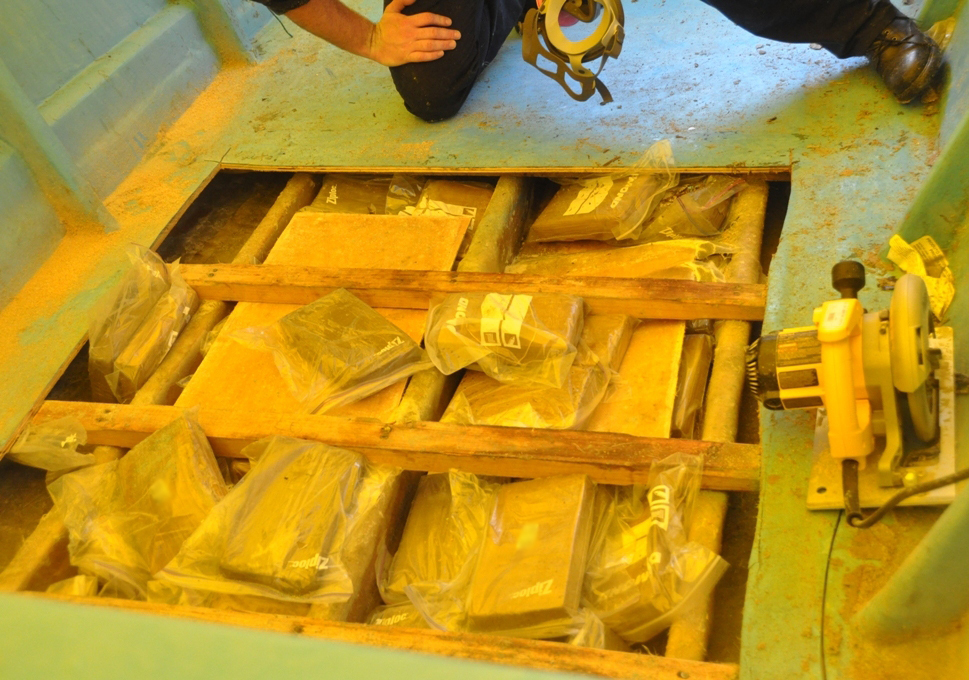 In this reference photo a crew member from the U S Coast Guard Cutter Bertholf inspects bales of cocaine discovered beneath the decks of a suspected smuggling vessel May 29 2013 After the suspicious vessel was detected by a U S Customs and Border Protection maritime patrol aircraft in international waters approximately 300 miles southwest of Coca Island Costa Rica Boutwell employed an unmanned aircraft system and crews aboard a Coast Guard MH-65D helicopter and two interceptor boats to track intercept search and seize the craft and detain six suspected smugglers