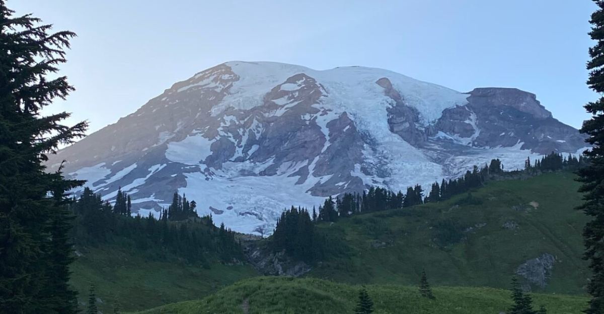 Image of Mount Rainer in the background with waterfall and bridge in the foreground