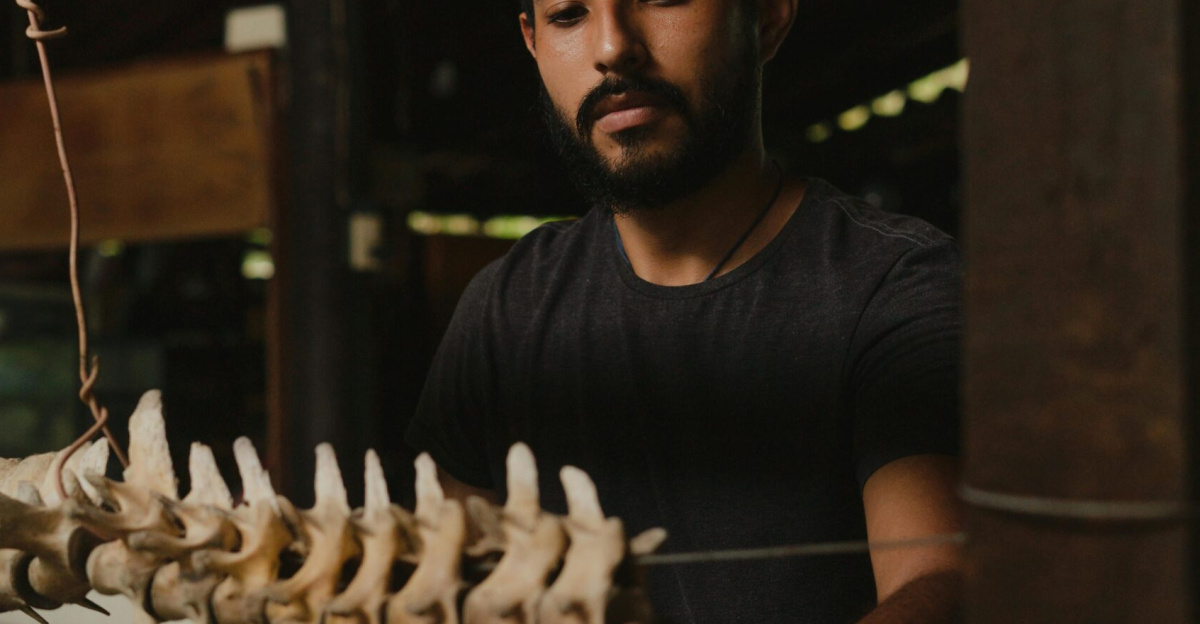 A man carefully inspects vertebrae, showcasing scientific exploration and discovery.