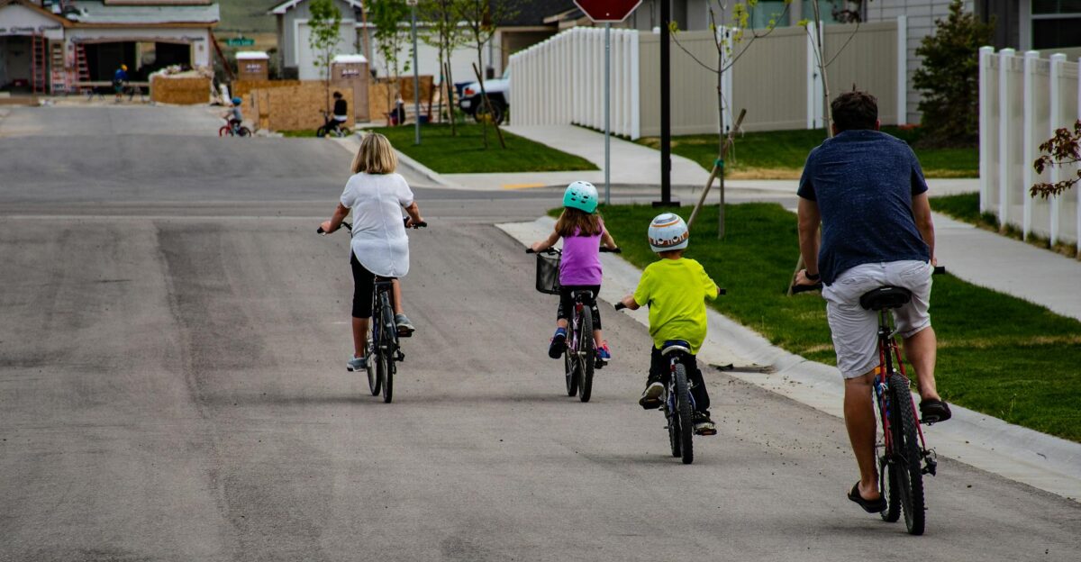 A family enjoys biking together on a suburban street highlighting active outdoor lifestyle