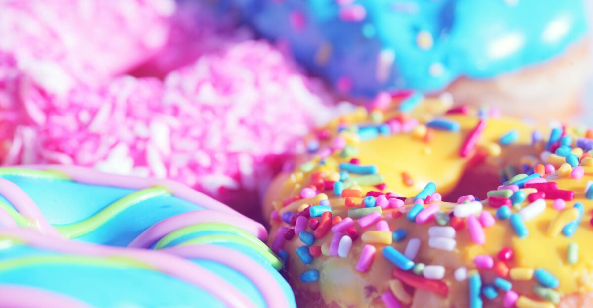 Close-up of assorted donuts with colorful icing and sprinkles showcasing sweet indulgence