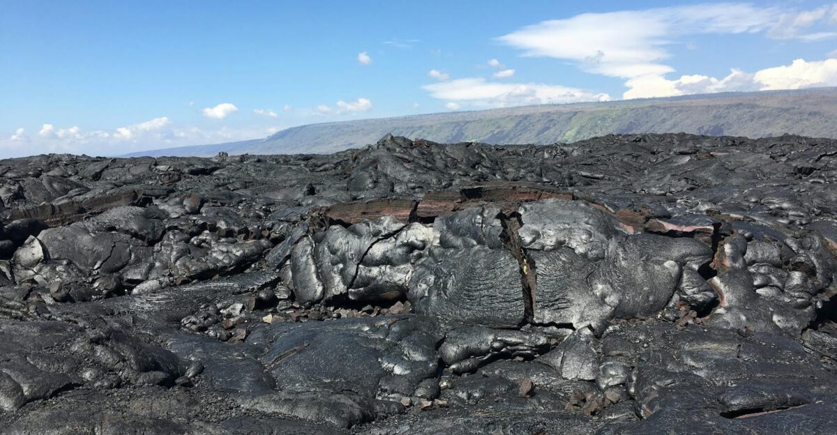 A broad view of solidified lava rocks under a clear sky in Volcano Hawaii