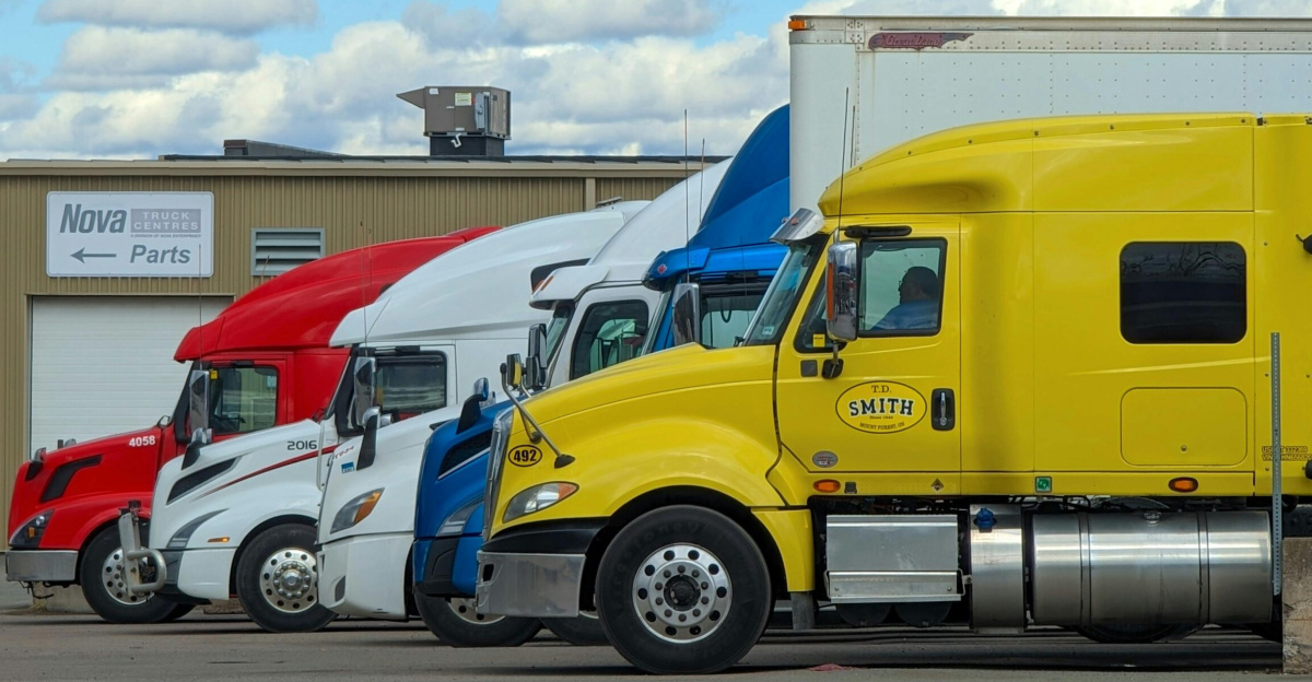 A vibrant lineup of semi trucks parked outside a Nova Truck Center in Truro, NS, Canada.
