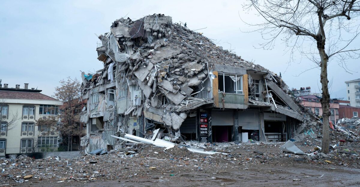 Collapsed building in urban landscape showing earthquake devastation and debris
