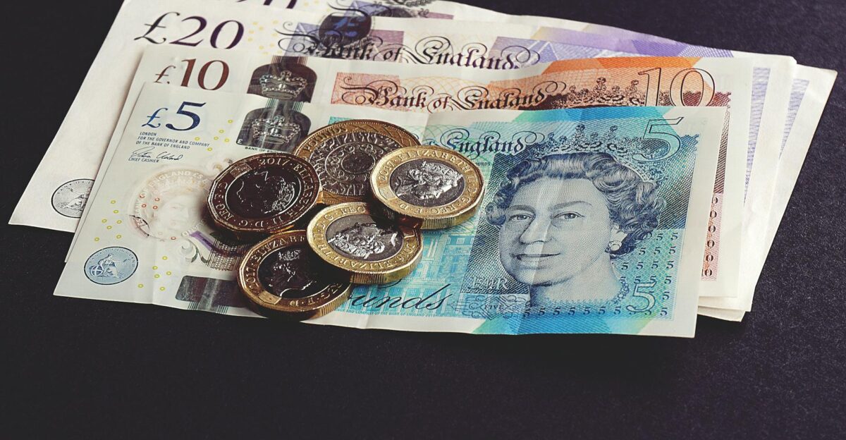 High-quality image of British pound notes and coins on a dark surface showcasing currency detail