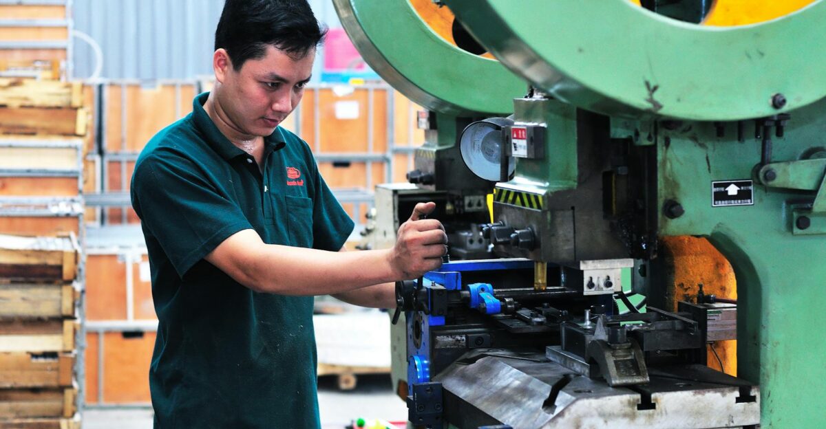 Man managing a machine in a factory setting focusing on production