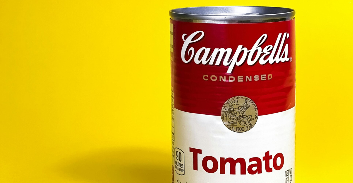 Classic Campbell's Tomato Soup can against a bright yellow background, perfect for pop art themes.