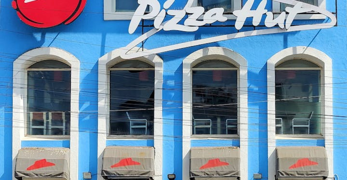 Blue facade of Pizza Hut with clear sky showcasing urban fast food architecture