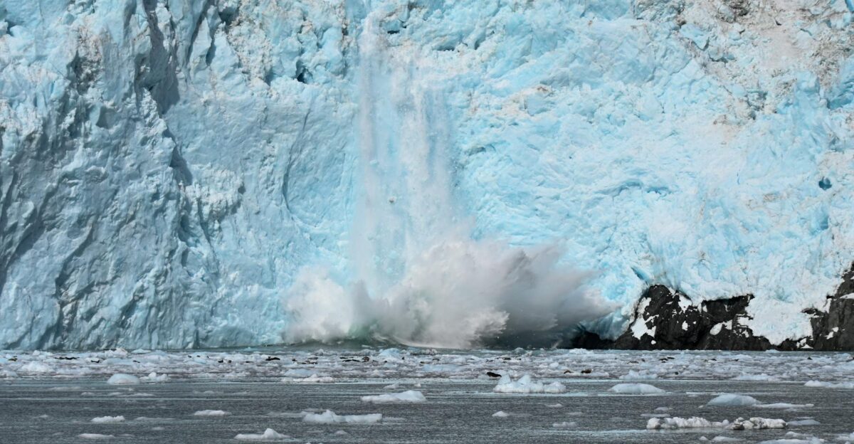 Dramatic glacier calving with ice chunks crashing into the sea showcasing nature s power