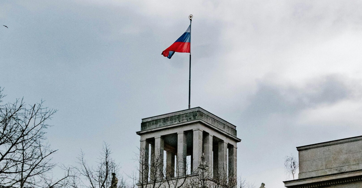 Historic Russian Embassy in Berlin with flag on rooftop amid clear sky.