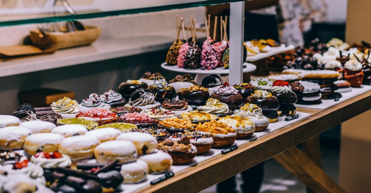 A tempting display of various donuts and pastries in a bakery Ideal for food lovers and culinary enthusiasts