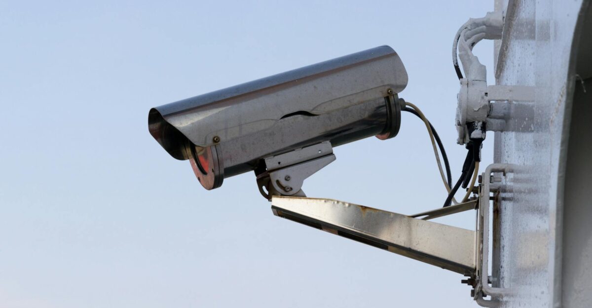 Close-up of an outdoor CCTV camera installed on a wall for security purposes