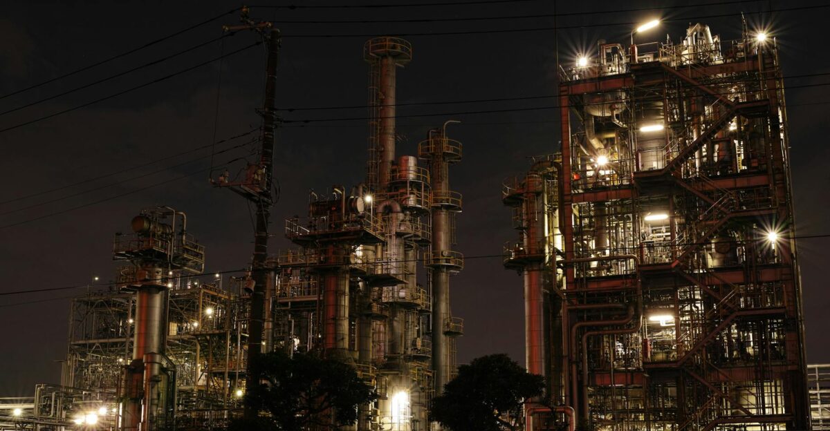 Night view of a brightly lit industrial facility showcasing intricate steel structures and machinery