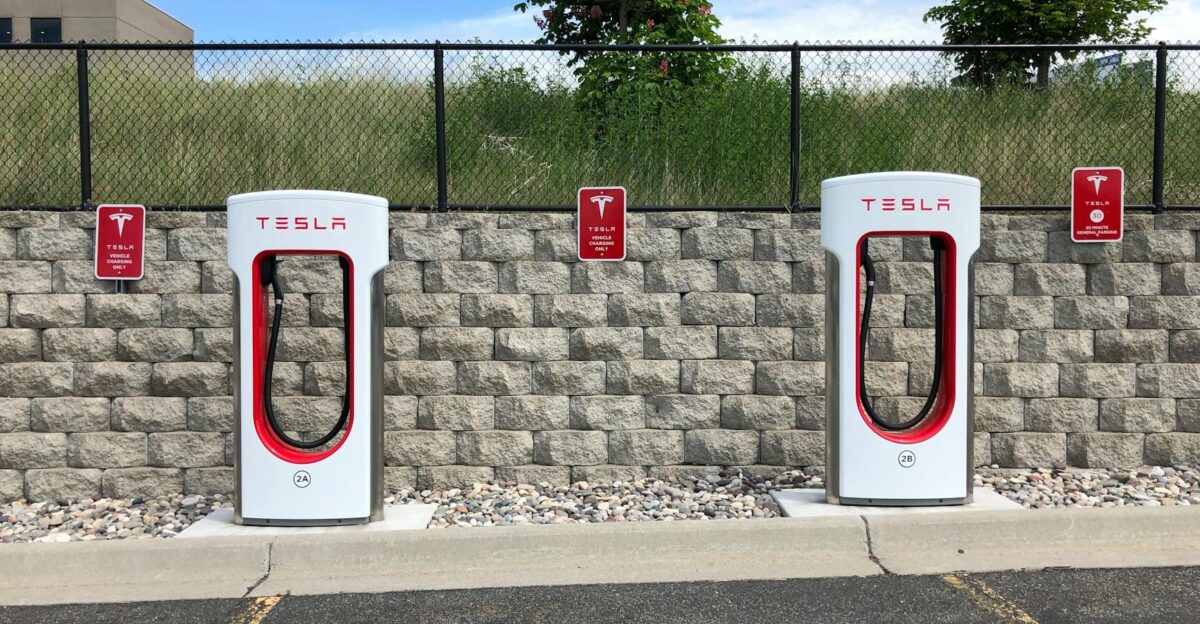 Dual Tesla electric car chargers in Idaho Falls parking lot with clear blue sky