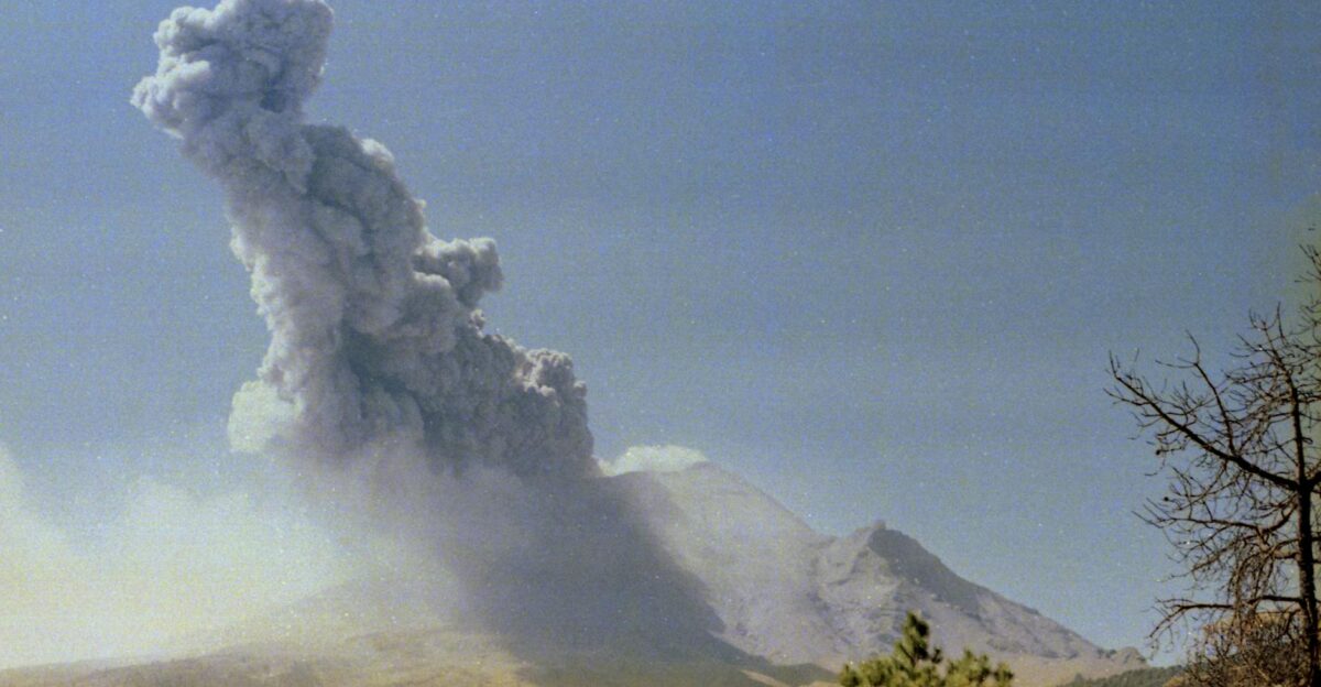 A powerful volcanic eruption with smoke plume rising into a clear sky