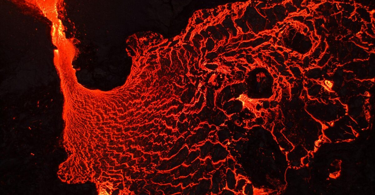 A breathtaking aerial view of flowing lava showcasing vibrant red hues and geological textures