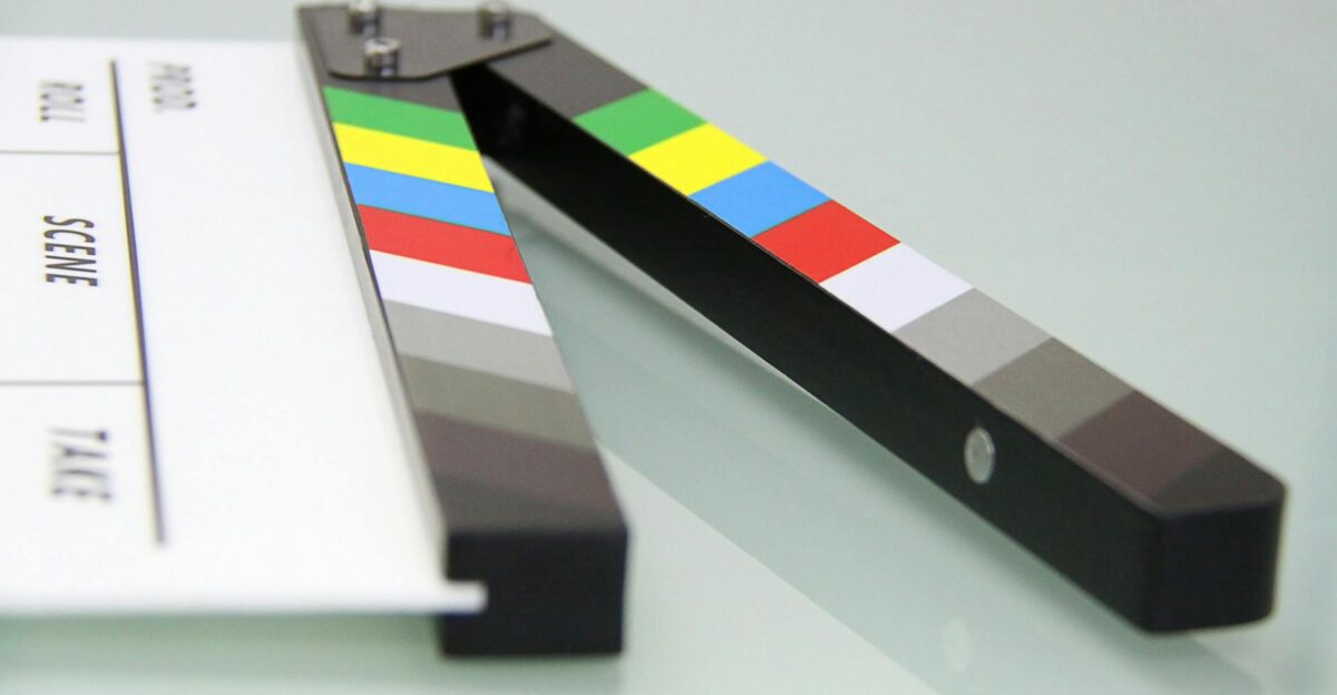 Colorful clapper board on a white surface used in filmmaking Ideal for entertainment and movie themes