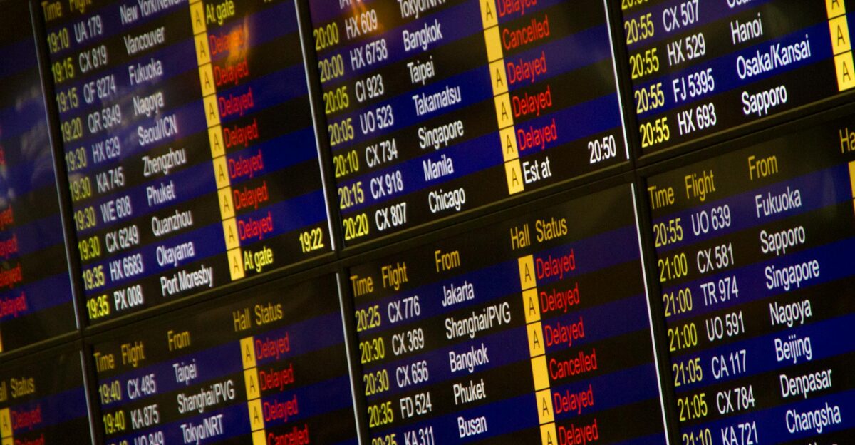 Close-up of digital flight information board showing arrivals and departures at an airport