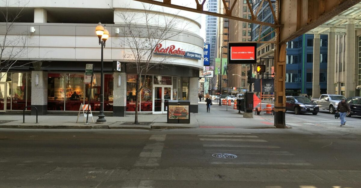 Street view of a Red Robin restaurant under an elevated railway in downtown Chicago