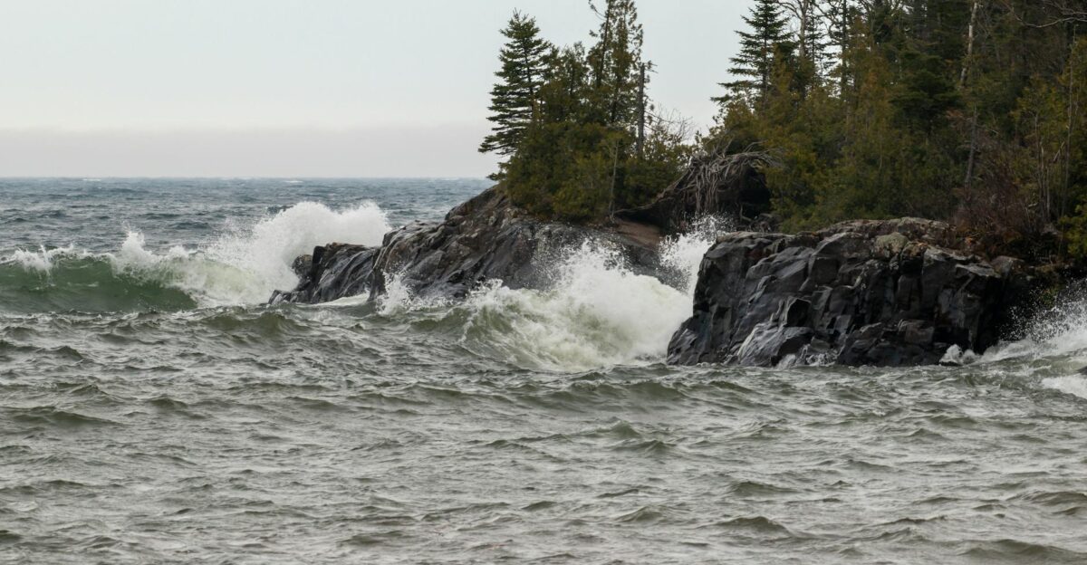 Dramatic scene of waves crashing against rocky Lake Superior shoreline