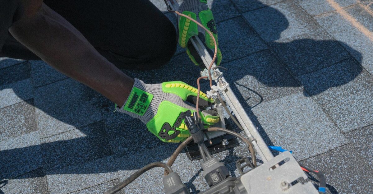 Close-up of a technician working on solar panel installation with green gloves in Tampa Florida