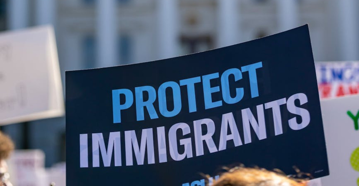 Sign reading Protect Immigrants seen at a protest in front of the California State Capitol in Sacramento