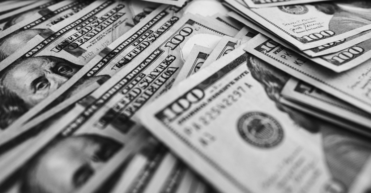 Monochrome image of scattered US hundred dollar bills representing wealth and prosperity.