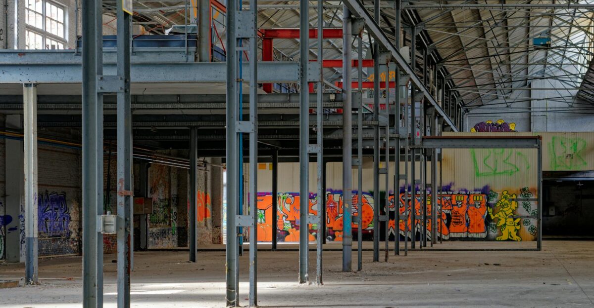 Graffiti-covered interiors of an abandoned warehouse showcasing urban art and industrial architecture