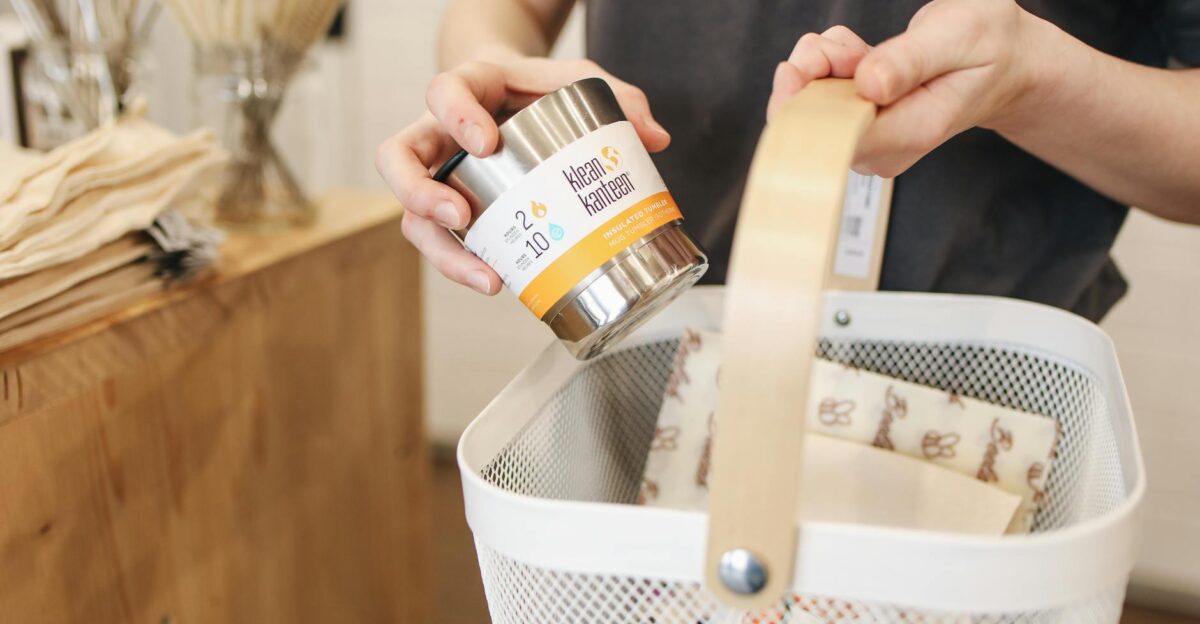 A person shopping in an eco-friendly store using reusable items and a shopping basket