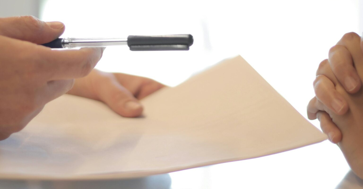 Close-up of a contract signing with hands over documents. Professional business interaction.