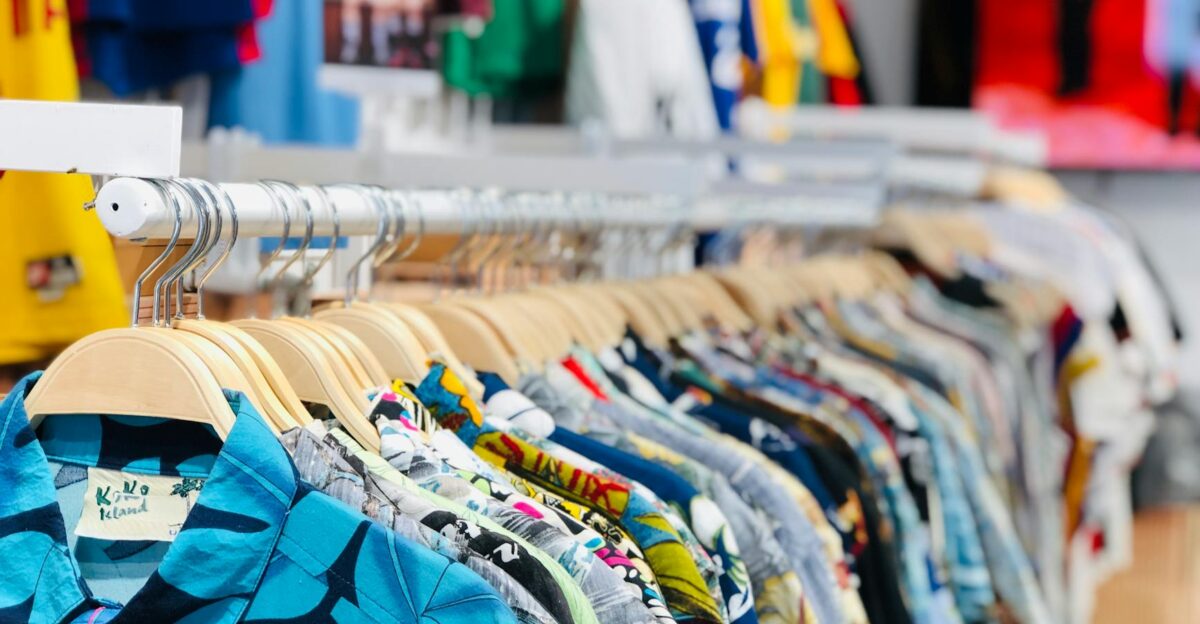 A vibrant collection of Hawaiian shirts on hangers in a clothing store with varied designs and colors