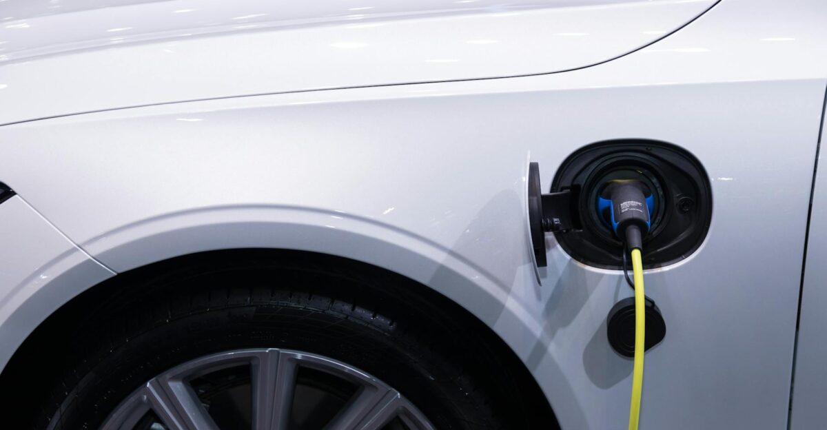 A white electric car is plugged in for charging close-up view of the charging port