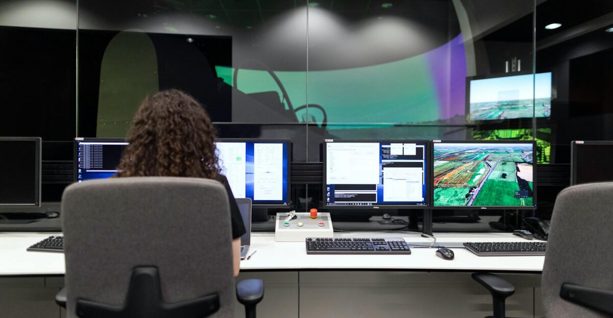 Female engineer managing multiple screens during a technology simulation in a control room