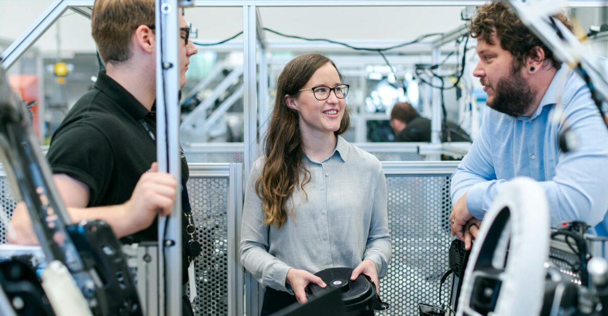Group of engineers collaborating on a project in a tech-focused industrial setting