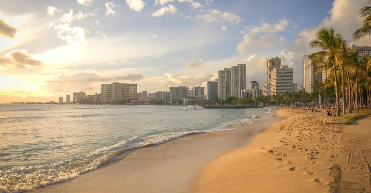 Experience the serene beauty of Honolulu s beach at sunset featuring the city s stunning skyline