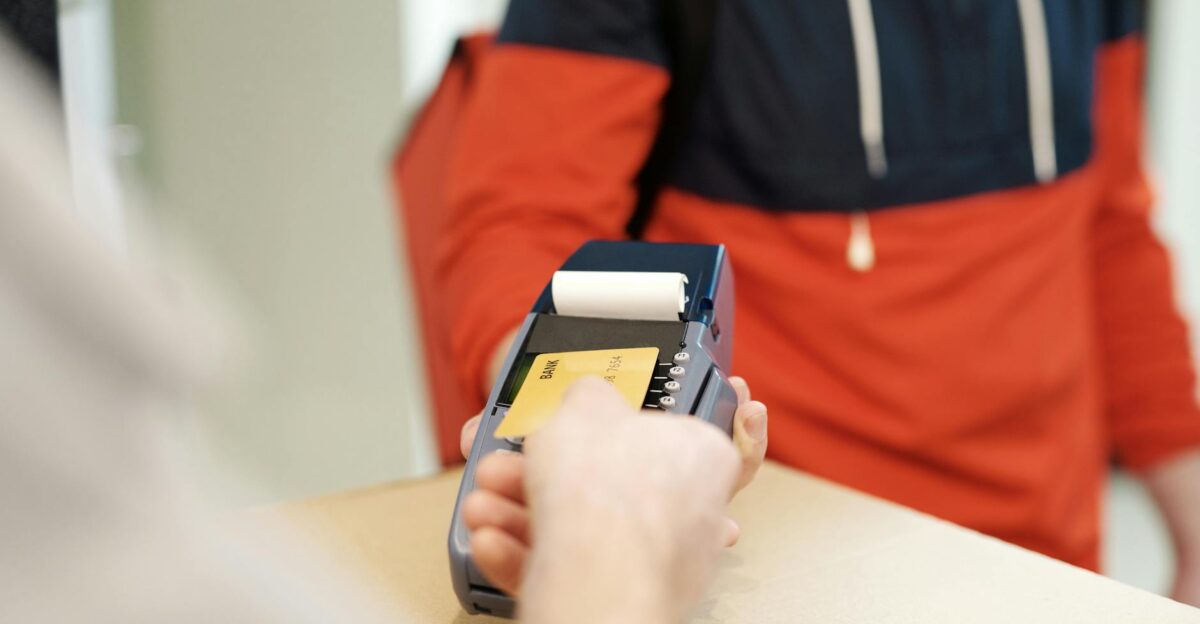 Close-up view of a contactless payment transaction using a credit card on a terminal device