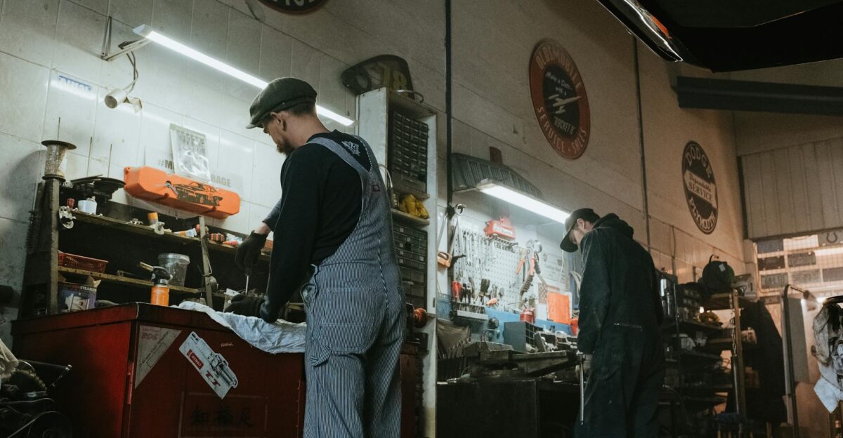 Two mechanics in a garage working on vehicle repair and maintenance