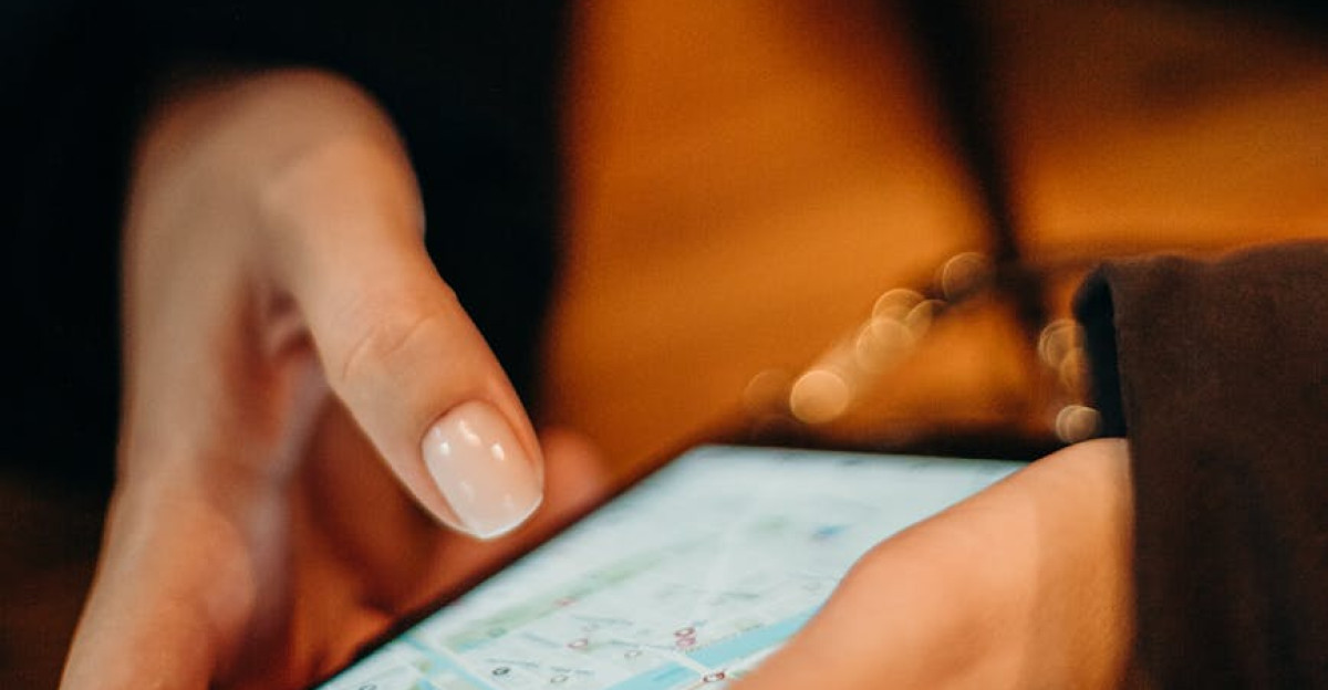 Close-up of hands using a smartphone for map navigation indoors