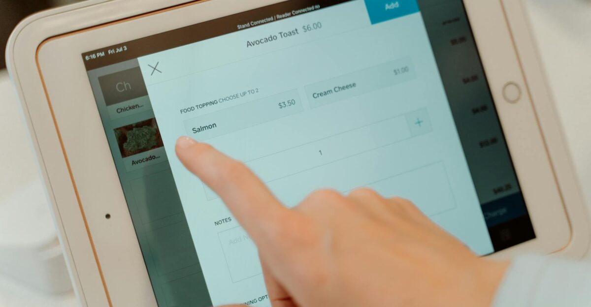 Close-up of a person s finger interacting with a point of sale tablet screen