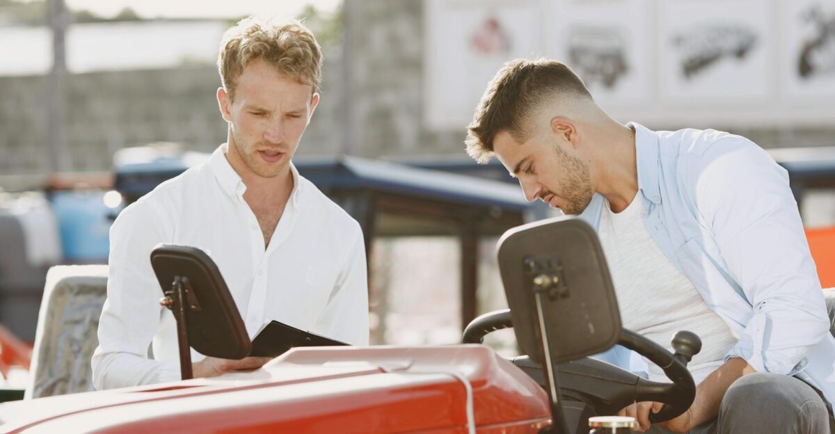 Two men engaging in a detailed discussion regarding a farm equipment purchase outdoors