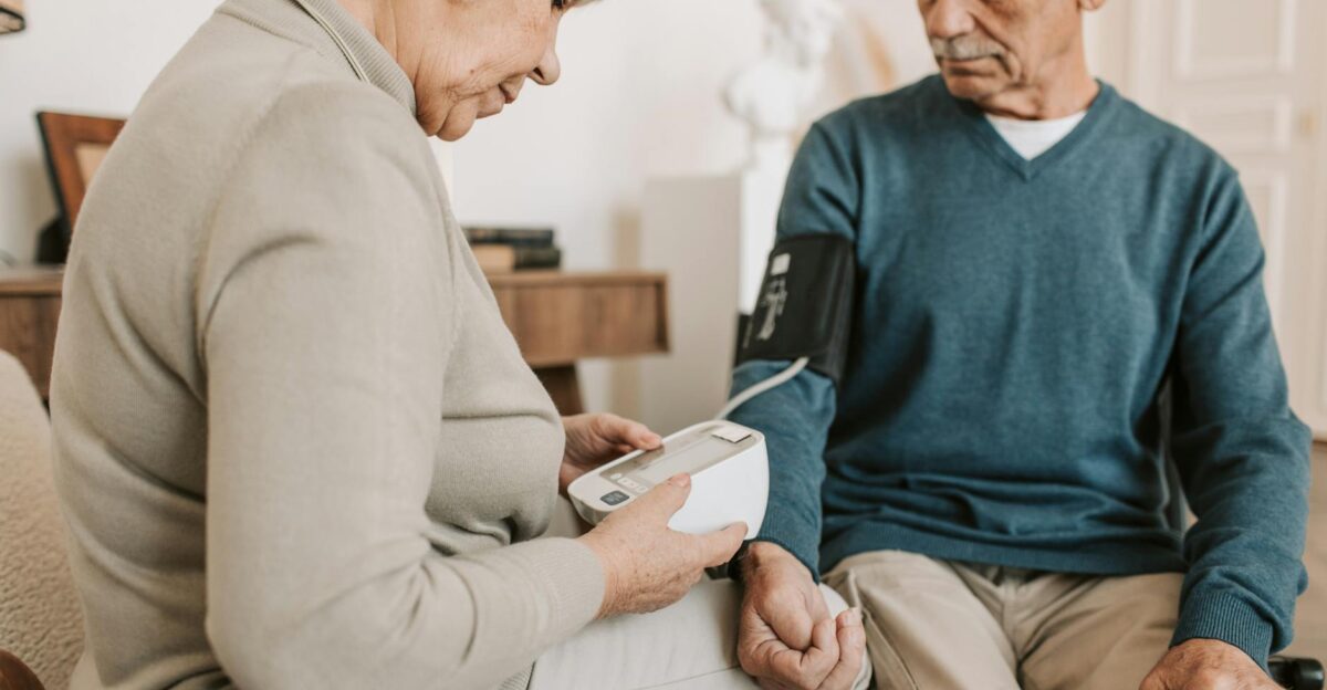 Senior couple at home using a sphygmomanometer to monitor blood pressure promoting elderly health care