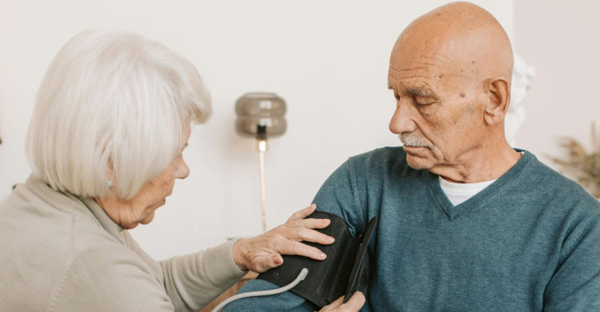 Elderly couple involved in a home blood pressure checkup, emphasizing health and care.