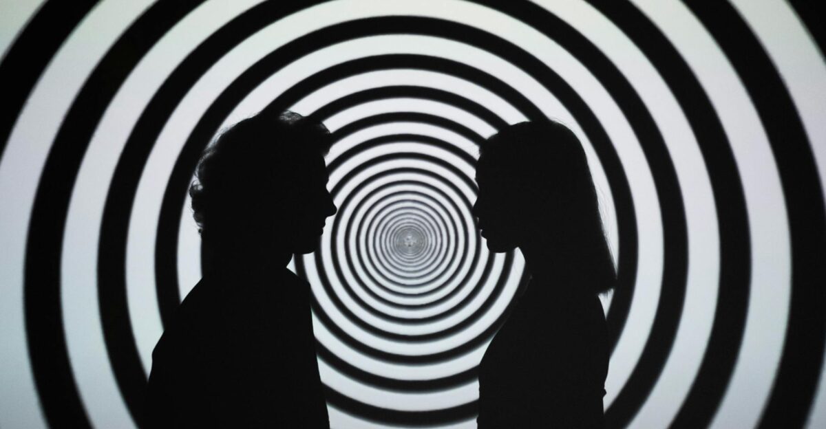 Silhouette of people facing each other with a hypnotic spiral background creating an optical illusion