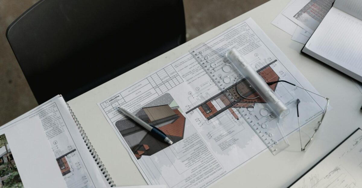 Top view of architectural blueprints and drafting tools on a workspace desk